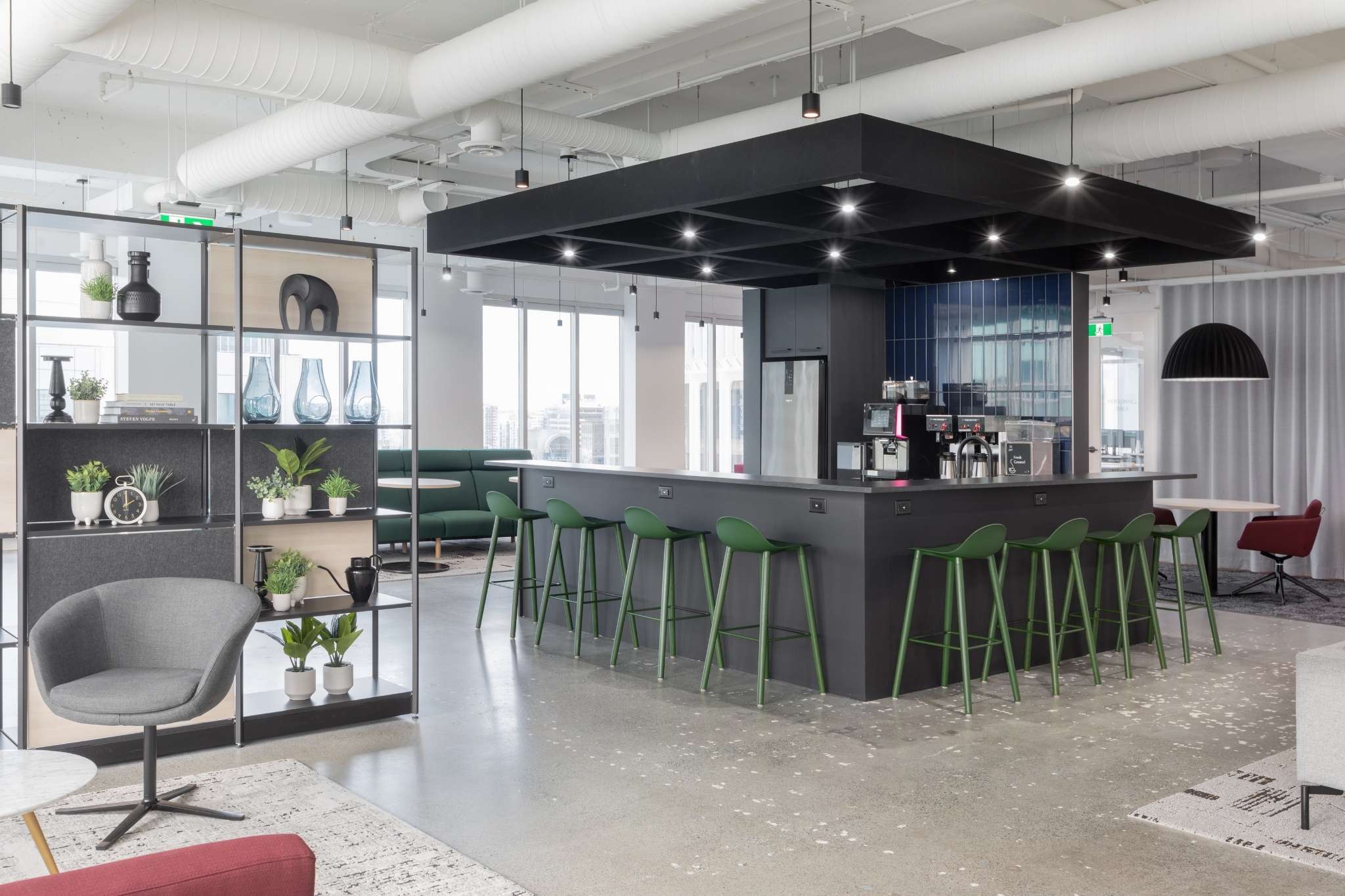 The top of a staircase with a wooden planter to the side and a large TV as you go down the stairs
