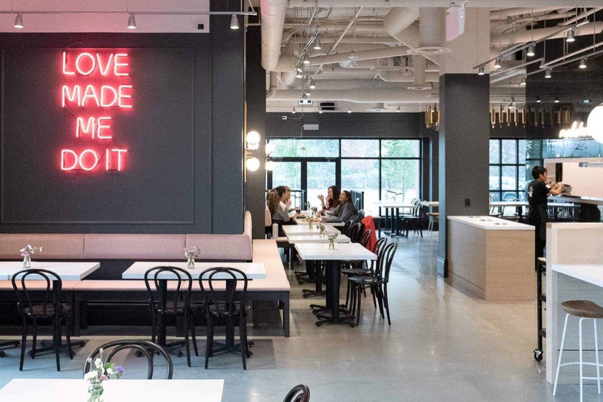 The top of a staircase with a wooden planter to the side and a large TV as you go down the stairs