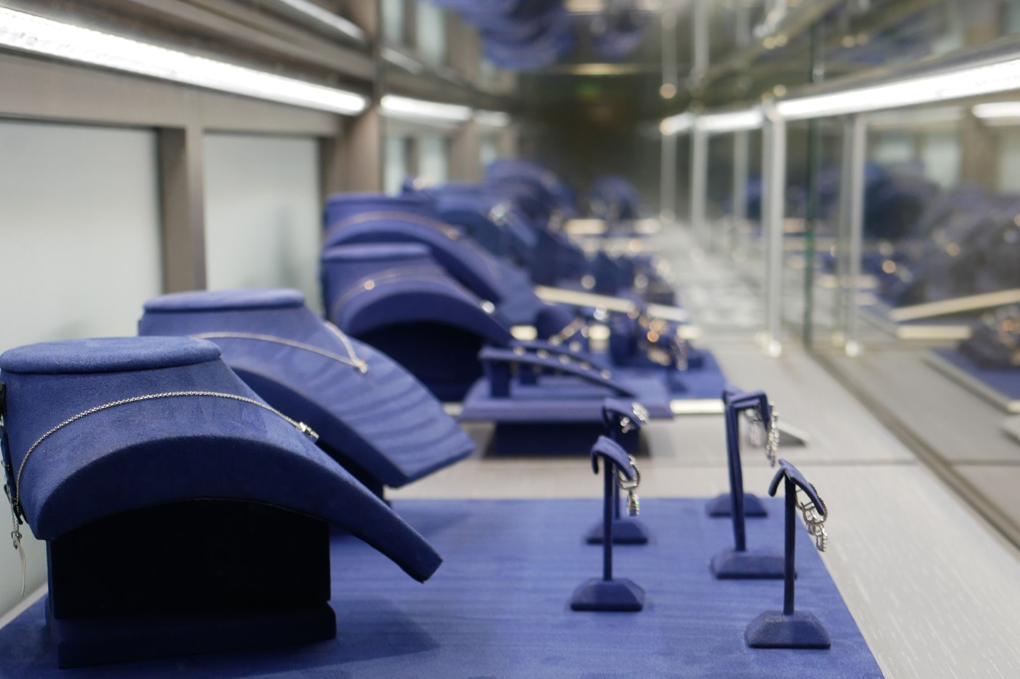 The top of a staircase with a wooden planter to the side and a large TV as you go down the stairs