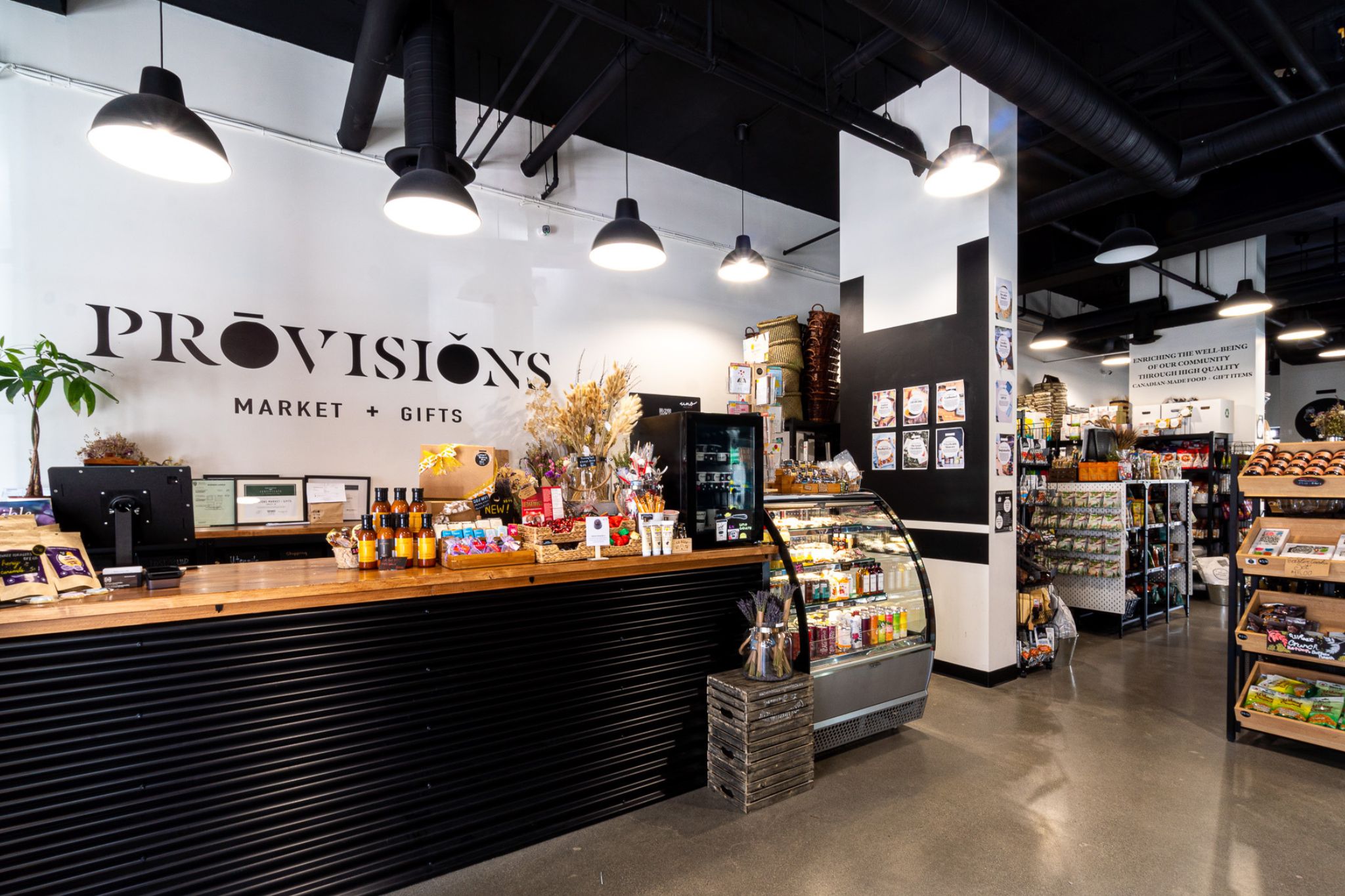 The top of a staircase with a wooden planter to the side and a large TV as you go down the stairs