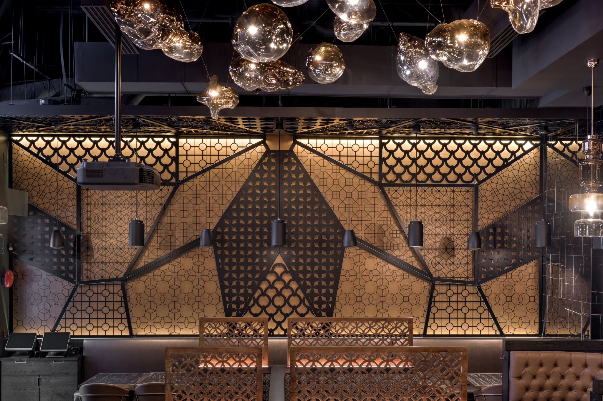 The top of a staircase with a wooden planter to the side and a large TV as you go down the stairs