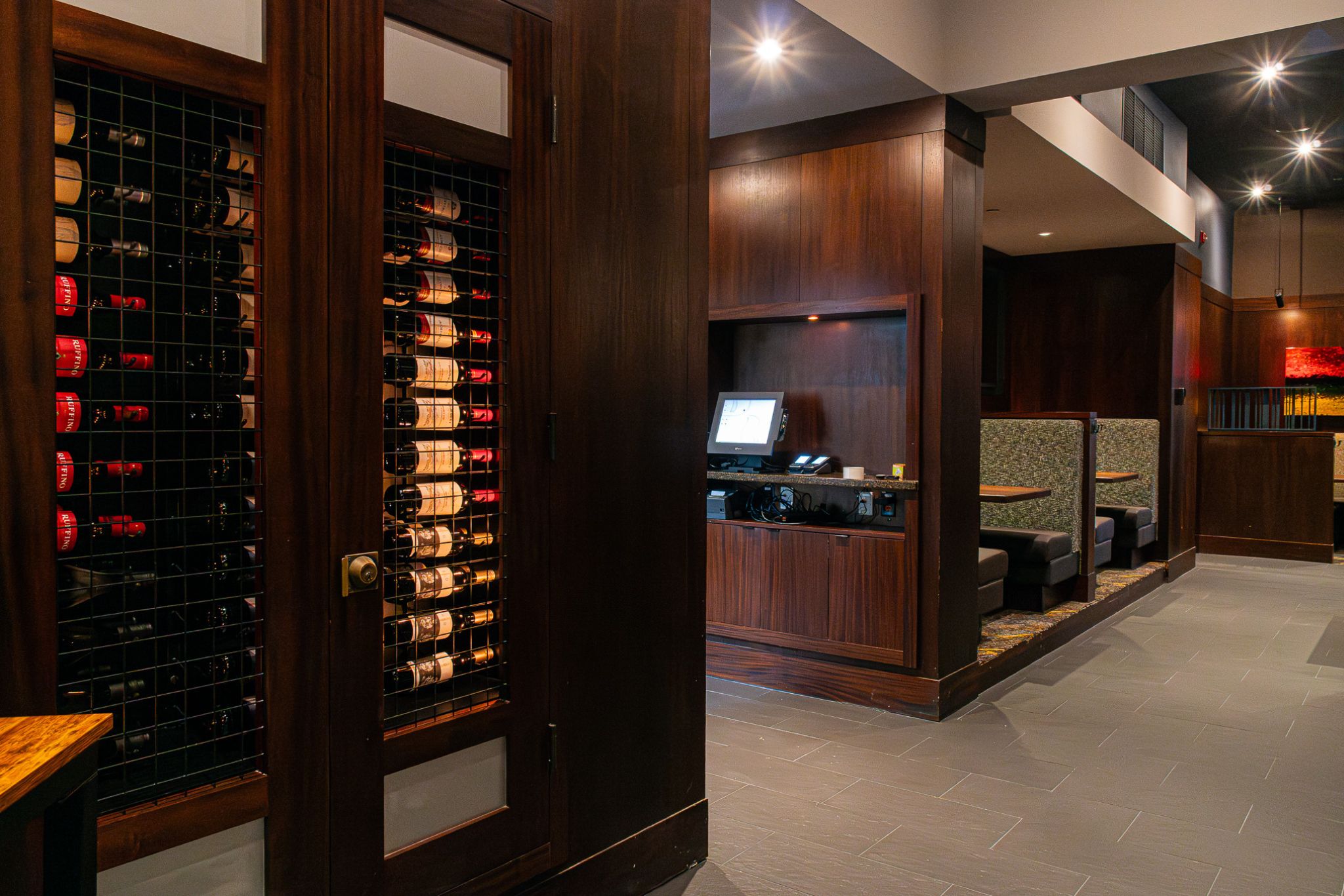 The top of a staircase with a wooden planter to the side and a large TV as you go down the stairs