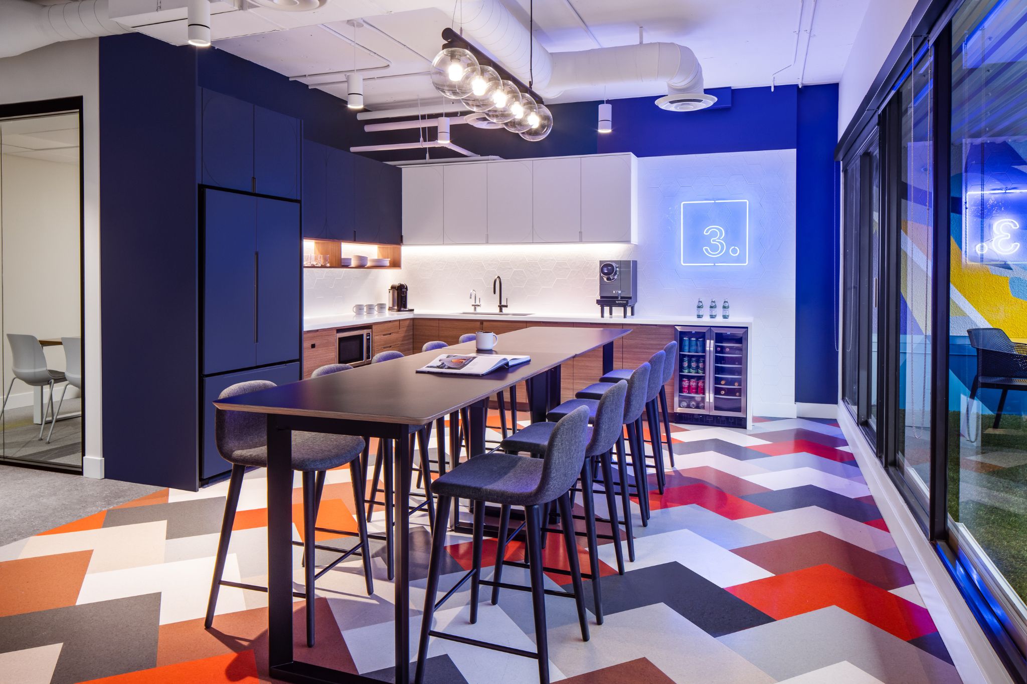 The top of a staircase with a wooden planter to the side and a large TV as you go down the stairs